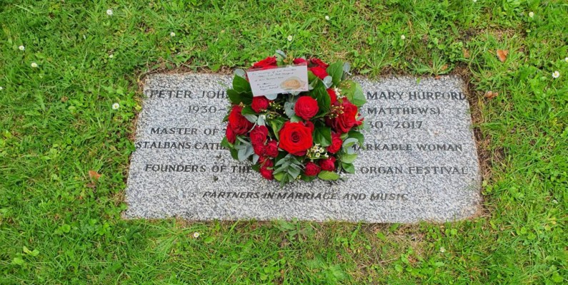 flowers laid on headstone with inscription celebrating PETER HURFORD and PAT HURFORD founders of the Festival